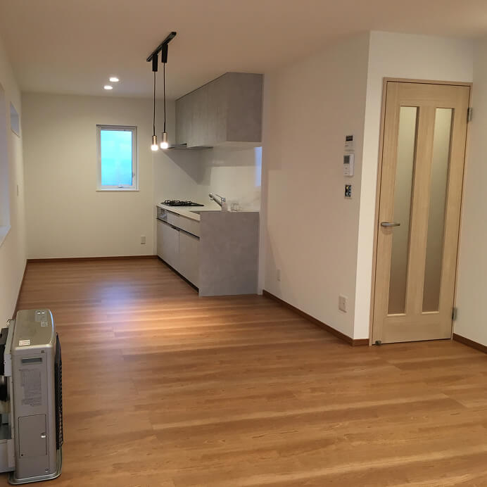 木目の床と間接照明が温かみを感じさせる明るいリビングダイニング