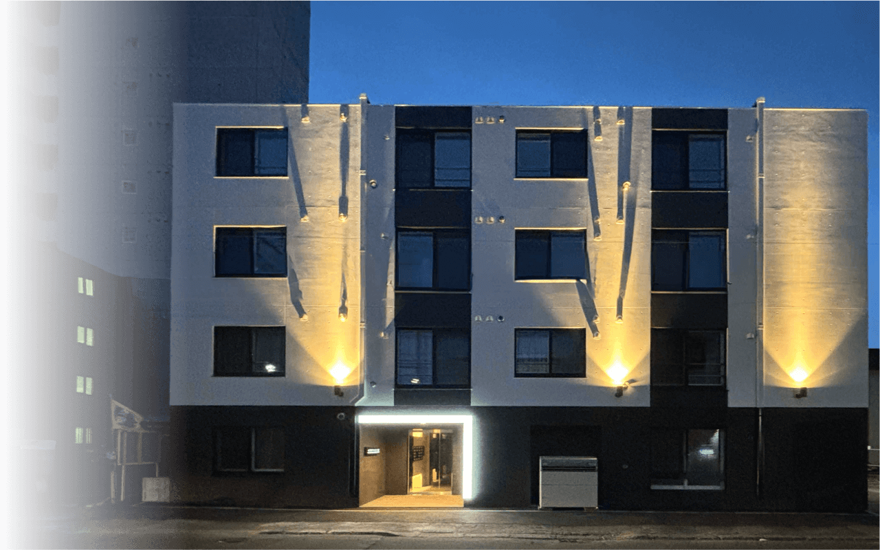 ライトアップされた4階建ての集合住宅の外観